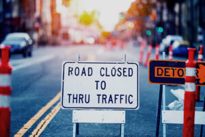 City street with construction block off that says "Road closed to thru traffic."
